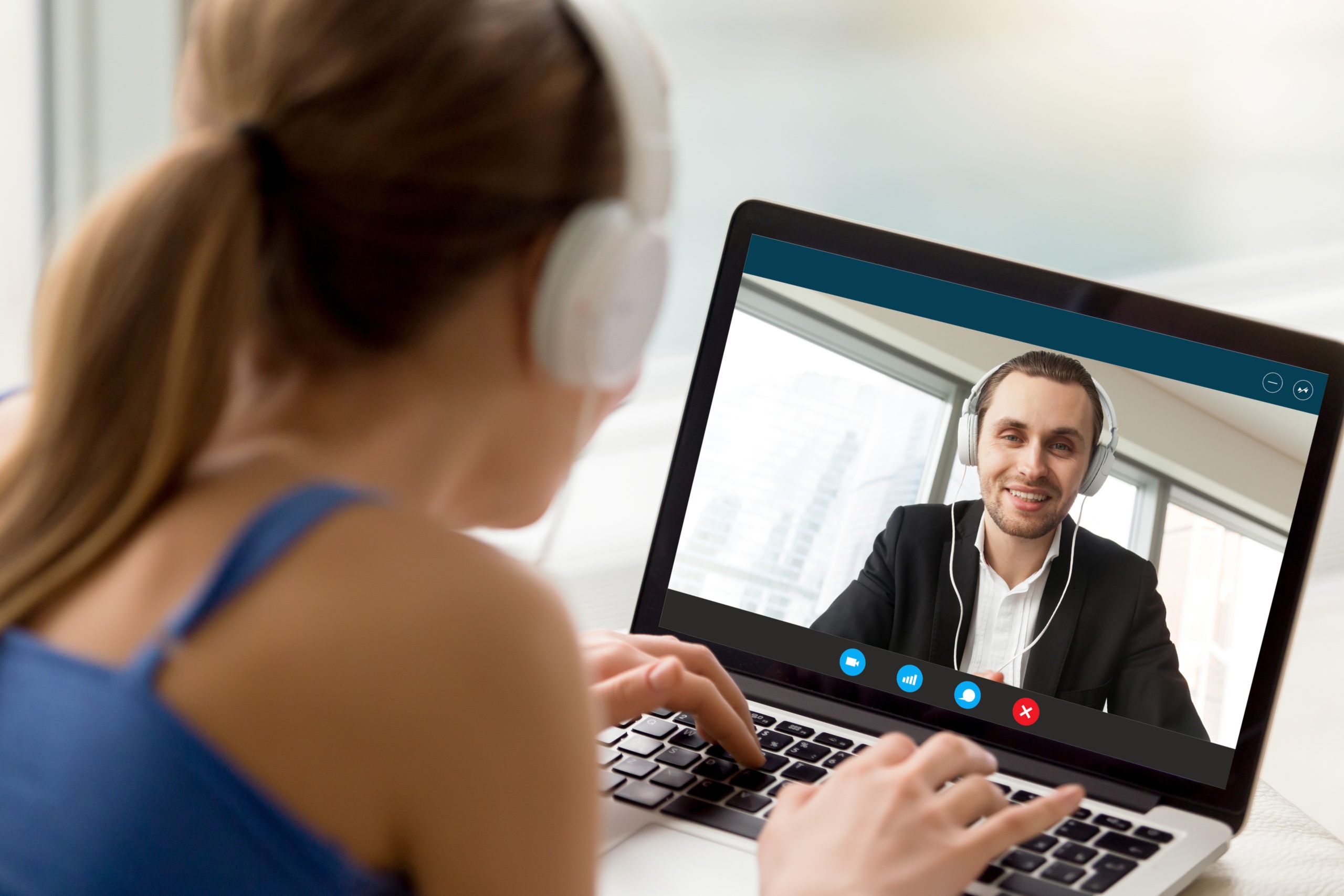 Man and woman in headphones communicating online by video call